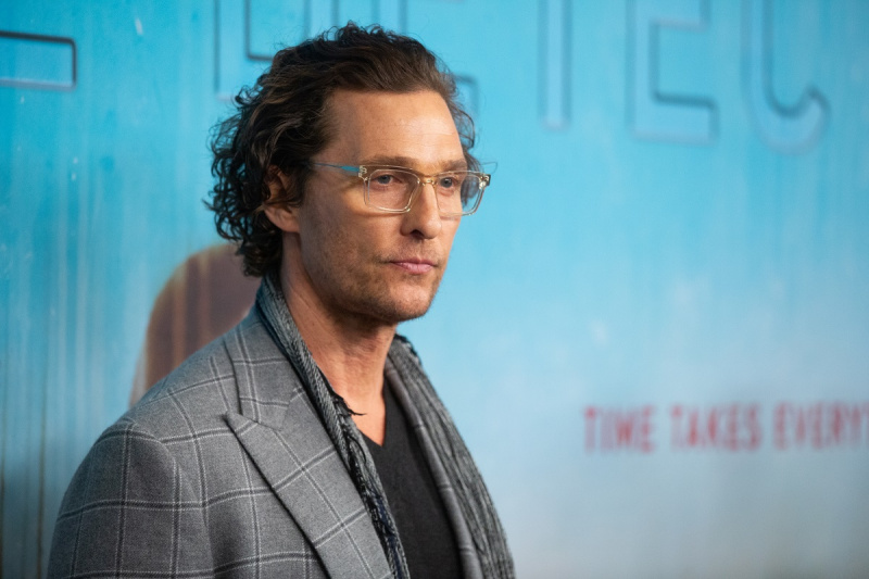   Matthew McConaughey posa mentre indossa un blazer grigio.