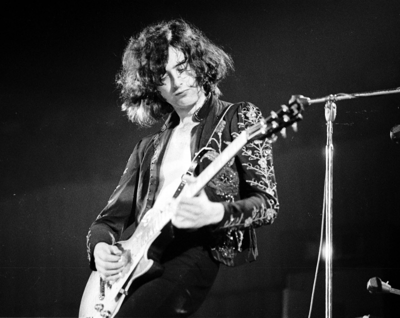   Uma foto em preto e branco de Jimmy Page tocando guitarra