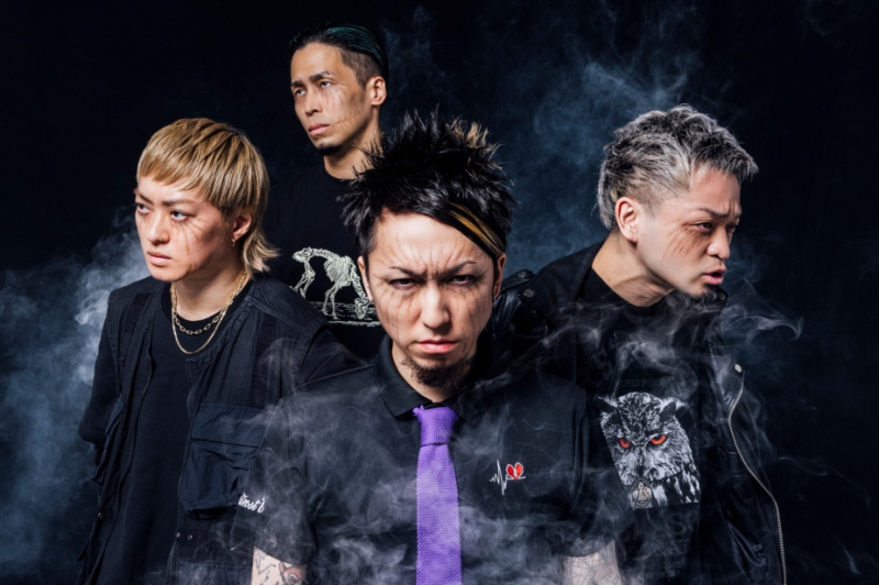   SiM, a banda japonesa por trás'Attack on Titan's hit theme, 'The Rumbling.' In the image, they all have makeup that looks like Titan markings under their eyes.