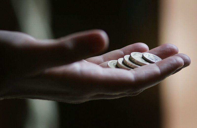 En utstrakt hånd som inneholder løs forandring