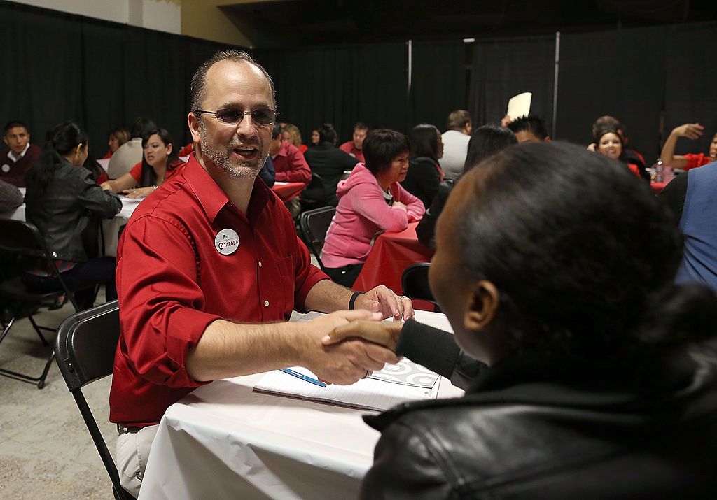 Um funcionário da Target cumprimenta um candidato a emprego no início de uma entrevista durante uma feira de empregos