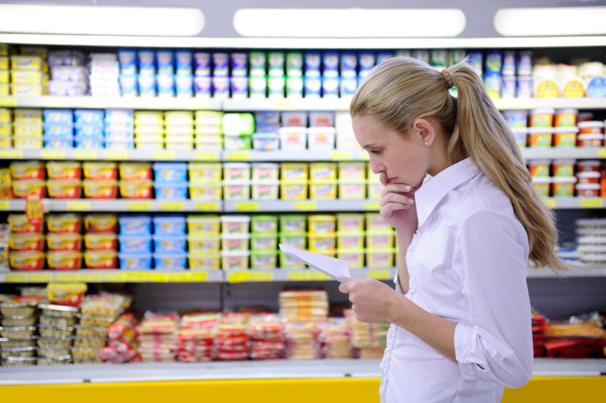 moteris, tikrindama savo maisto prekių sąrašą, būdama parduotuvėje